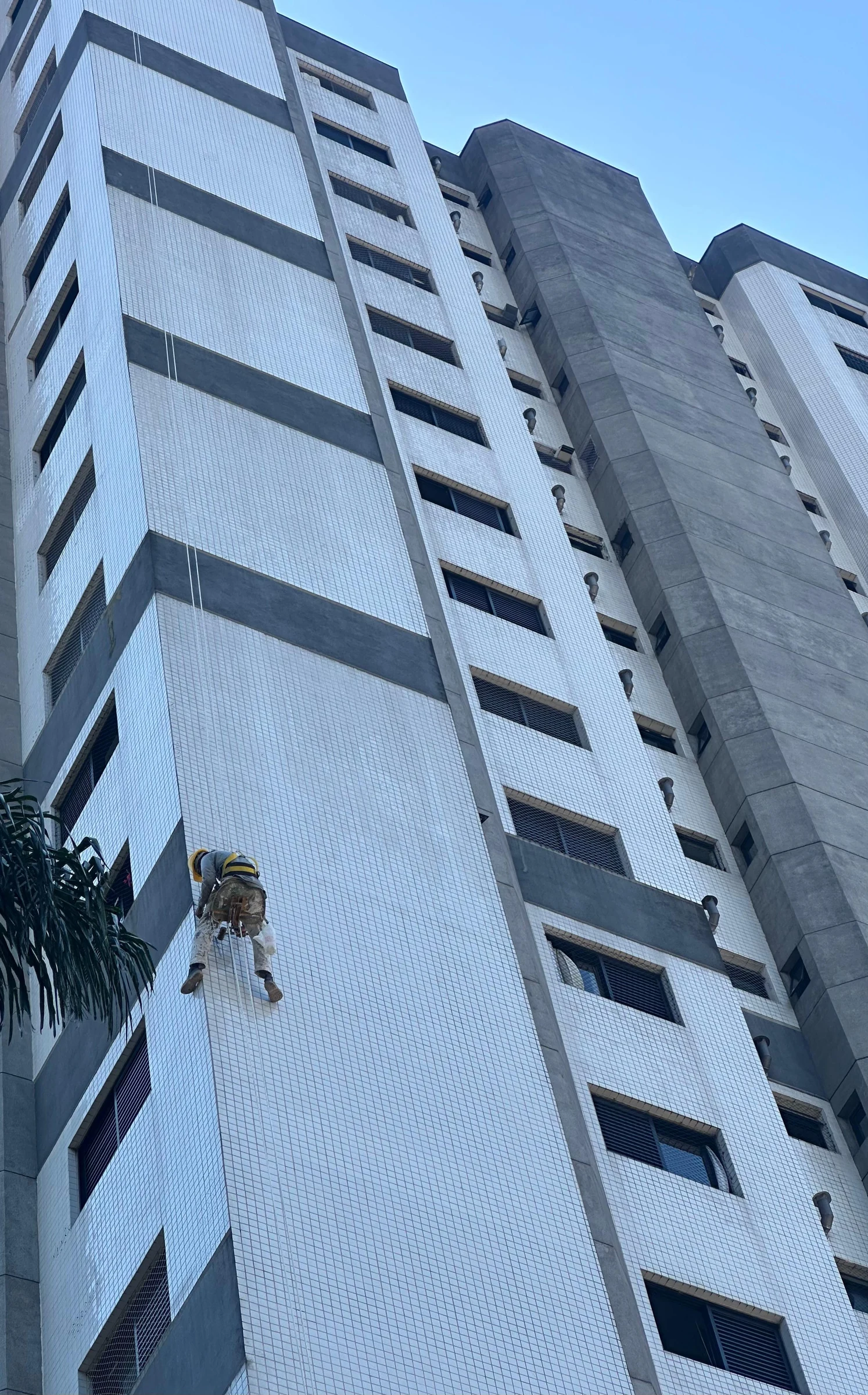 Profissional executando serviço em altura na fachada de um edifício